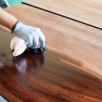 Applying varnish to a wooden tabletop