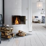 Logs of firewood in front of the fireplace in the kitchen-living room